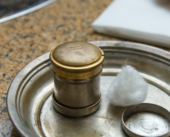 Am Rand eines Taufbeckens stehen Chrisamöl und eine Muschel für das Taufwasser.